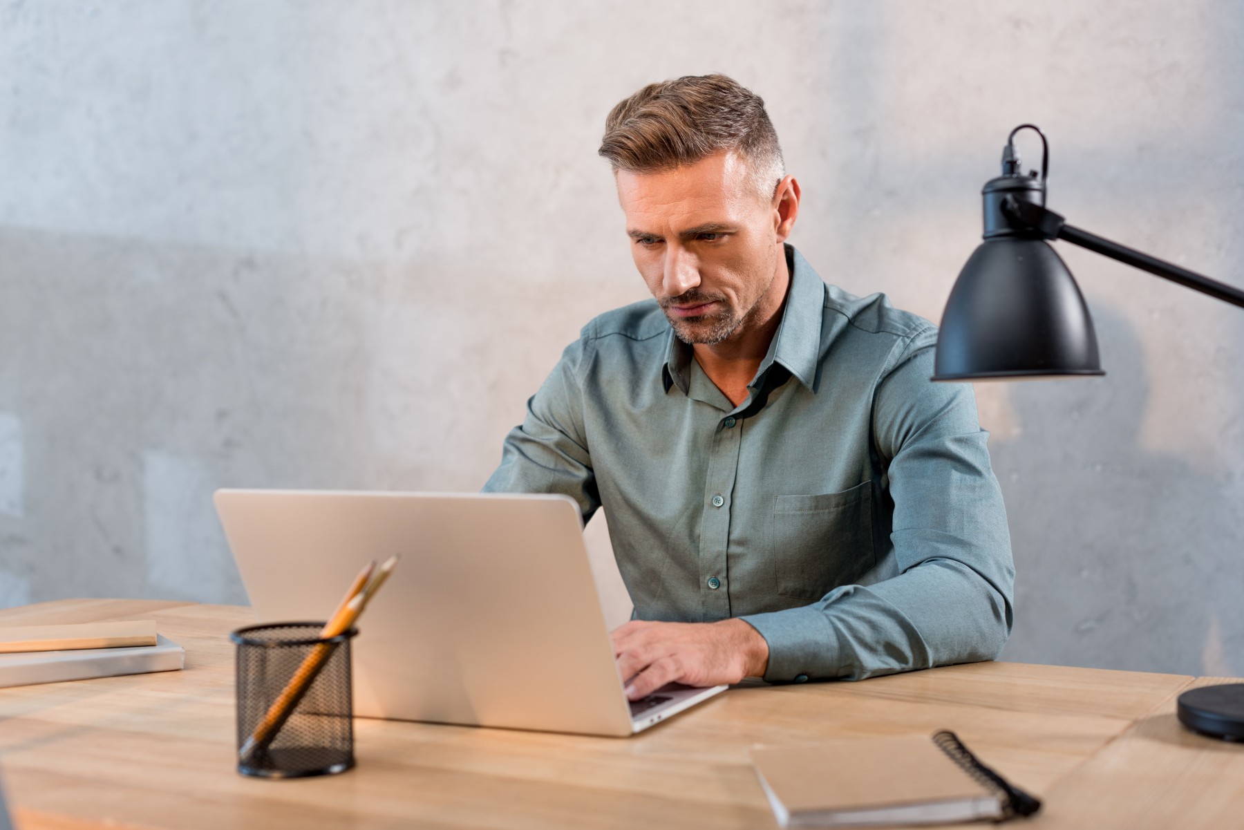 handsome man sitting at desk and using laptop in o 2023 11 27 04 56 34 utc 1 1.jpg