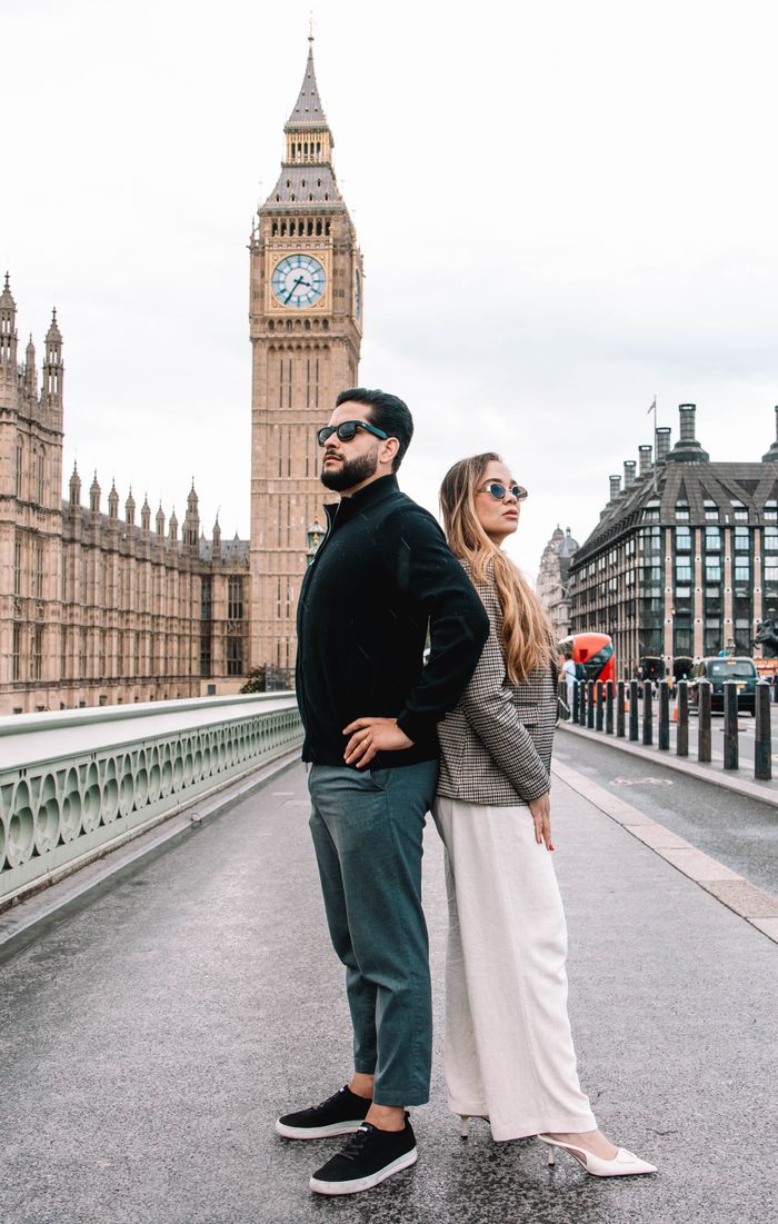 A fashionable couple stands confidently before London's iconic Big Ben, capturing the essence of urban exploration.
